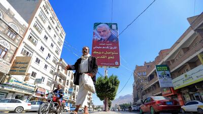 A Yemeni man walks beneath a poster of assassinated Iranian military commander Qassem Suleimani in the capital Sanaa. AFP
