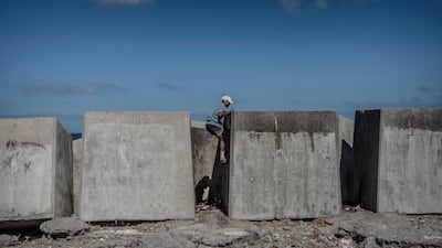 A man slips as he climbs over the breakwater near a temporary migrant camp on El Trampolín beach, in the Spanish enclave of Ceuta, North Africa. Getty Images