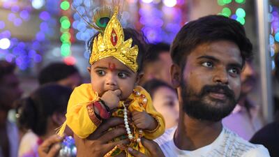 A man carries his child dressed as Krishna in Amritsar. AFP