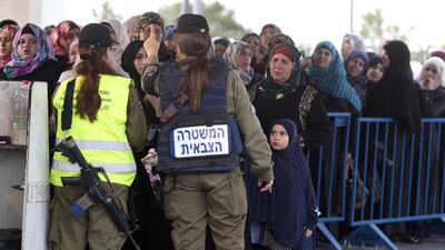 Israeli soldiers carry out security inspections of female Palestinians as they cross through the military checkpoint at Bethlehem early on June 26, 2015, to enter Jerusalem and attend the 2nd Friday prayers during Ramadan at the Al Aqsa Mosque. Jim Hollander/EPA
