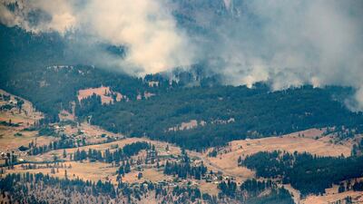 A wildfire burns in the mountains north of Lytton, British Columbia, Canada, during record high temperatures. Darryl Dyck / The Canadian Press via AP