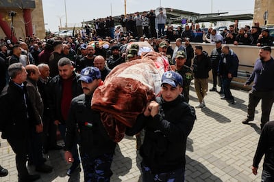Palestinian security personnel carry the bodies of women killed after an Iranian missile attack. Reuters