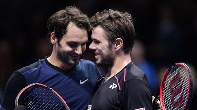 Roger Federer, left, commiserates with fellow Swiss Stan Wawrinka after beating him in a men's singles semi-final match on Day 7 of the ATP World Tour Finals tennis tournament in London on November 21, 2015. Federer won 7-5, 6-3. Leon Neal / AFP