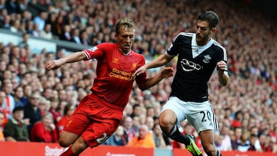 Southampton midfielder Adam Lallana, right competes with Liverpool’s Lucas Leiva. Paul Ellis / AFP