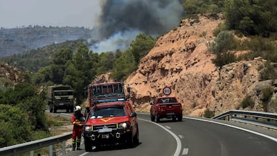 Emergency vehicles are seen near a forest fire. EPA