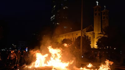 Protesters burn dumpsters as they block the road near the Maronite Catholic Church of Saint Maroun during ongoing protests in Beirut. EPA