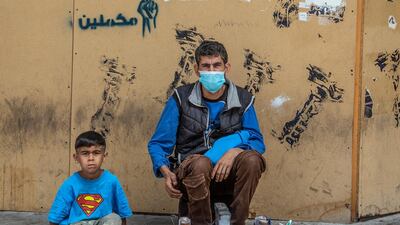 A shoe polisher and his son wait for customers on Hamra Street, Beirut. EPA
