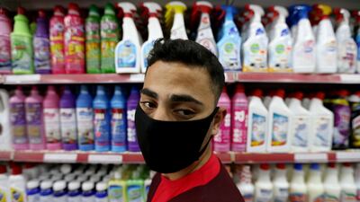 A Palestinian man wearing a mask looks on as he stands in front of disinfectants and cleaning products at a supermarket in the southern Gaza Strip. Reuters
