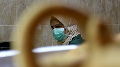 A Palestinian woman wearing a mask looks on as she makes traditional cakes in preparation for the upcoming holiday of Eid al-Fitr marking the end of Ramadan, in the southern Gaza Strip. Reuters