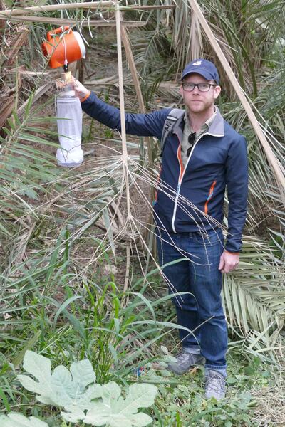 Dr Jeremy Camp with the mosquito traps that were used to collect the creatures at Al Ain Oasis. Photo by Norbert Nowotny