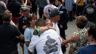 People embrace at the National September 11 Memorial. EPA