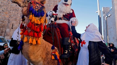 The Jerusalem Santa, a Palestinian dressed up as Father Christmas greets Eastern Orthodox nuns as he rides a camel in Jerusalem's Old City , as Christians around the world prepare to celebrate the holy day. AFP