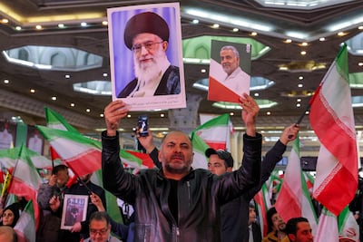 A man holds posters of Iran's supreme leader Ayatollah Ali Khamenei and Qassem Suleimani, deceased commander of the Islamic Revolutionary Guard Corps’ Quds Force, during a memorial ceremony marking the 40th day of mourning for victims of "terrorism" killed in anti-government protests in Iran, at the Tehran Musalla. AFP