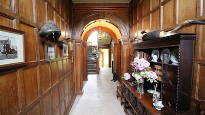 The entrance hall maintains its wooden walling making for an imposing throughway. Courtesy Savallis