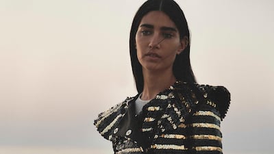 lack and gold coat with sequins; ecru dress in fine jersey (worn underneath); gold belt in leather and resin; and 11.12 bag in embossed gold leather, all from Chanel.