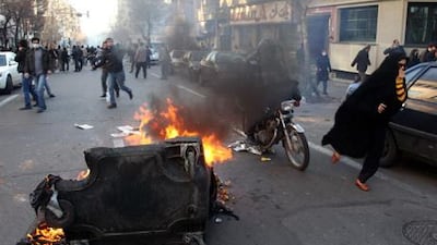 A garbage container is set on fire as Iranian protesters stage an anti-government demonstration, under the pretext of rallies supporting Arab uprisings, in Tehran yesterday.