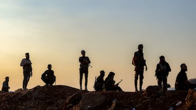 Syrian troops stand by as a UN convoy evacuating families from Sweida moves through the buffer zone in Busra, Daraa province. AFP