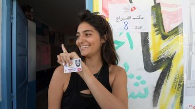 A Tunisian woman displays her ink-stained finger after casting her ballot at a polling station in the capital Tunis during the legislative. AFP