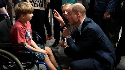 Prince William talks to a young boy as he visits the accommodation centre for Ukrainians. AP