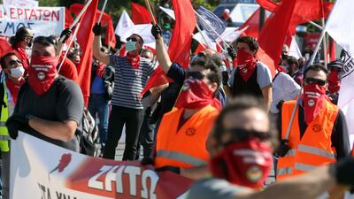 Members of the PAME movement and the KKE are holding flags, wear gloves and masks to protect themselves, and keep their distance from the rally for Labor Day on the Syntagma square in Athens, Greece. EPA