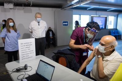 UK Prime Minister Boris Johnson watches a patient receiving a dose of the AstraZeneca Covid-19 vaccine during a visit to Barnet Football Club’s ground at The Hive, north London. Getty