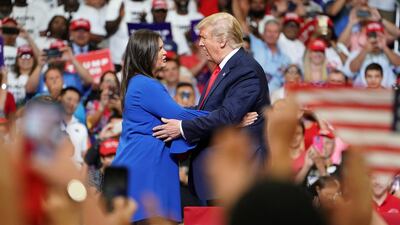 Donald Trump and press secretary Sarah Sanders hug at a campaign kick off rally at the Amway Center in Orlando, Florida. Reuters