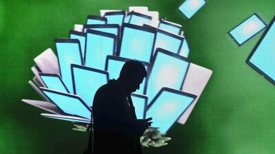 A participant checks a mobile device during the Mobile World Congress in Barcelona last year. Josep Lago / AFP