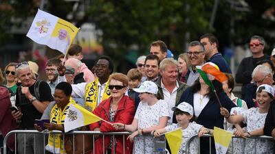 People wave at Pope Francis as he drives by. Reuters