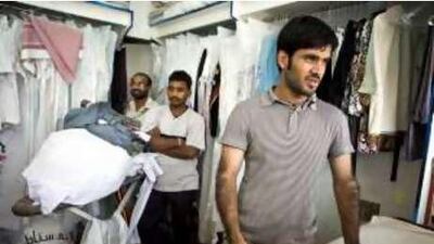 Wash around the clock: Ali Liaqat, 24 (right), Rakesh Kumar, 21 (centre), and Muzaffer Iqbal, 28 (back left) at Al Falah Laundry.
