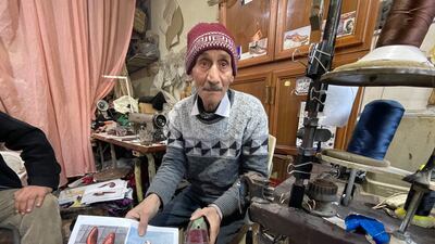 Mr Sharab holds a shoe he made based on a photo given to him by an Iraqi customer who found it on the internet