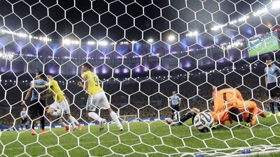 James Rodriguez, second right, begins to celebrate after scoring his second goal for Colombia in their 2-0 win over Uruguay on Saturday to advance to the 2014 World Cup quarter-finals. Marcio Jose Sanchez / AP