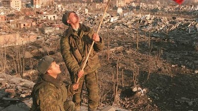 Russian soldiers raise a flag over the ruins of an apartment building in Grozny, Chechnya, in March 2000. AP Photo.