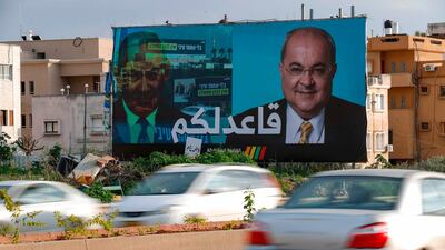 A picture taken on February 21, 2020, shows a portrait of Arab Israeli member of the Joint List Ahmad Tibi on a campaign poster, with Arabic writing stating, "I am staying seated for you" in the northern Israeli City of Tayyiba. AFP