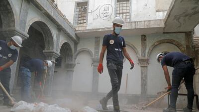Volunteers help clear a ruined church of rubble in Mosul. Reuters