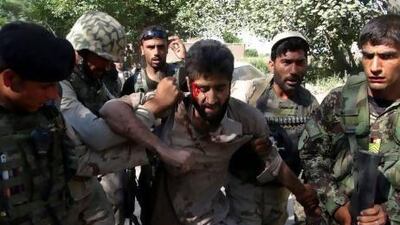 Afghan police carry an injured Taliban fighter, who was captured after an overnight clash with Afghan police in Jalalabad, in the eastern province of Nangrahar, east of Kabul.