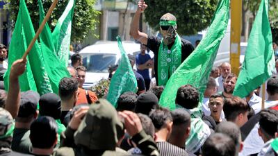 Palestinians wave flags and chant slogans in the occupied West Bank city of Hebron on July 31, 2024, during a demonstration denouncing the killing of Hamas leader Ismail Haniyeh. AFP