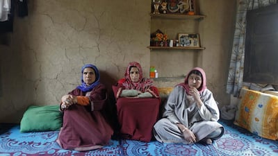 Saheema Akhtar wife of Mohammed Amin Pandith, a village council head, who was killed by militants, sits with relatives inside her house in Gulzarpora, south of Srinagar. Danish Ismail / Reuters