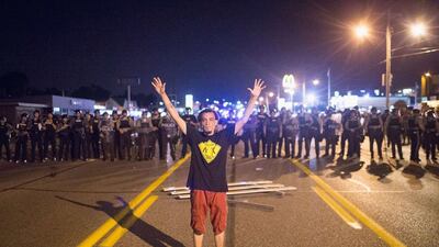 A demonstrator, marking the anniversary of the shooting of Michael Brown, confronts police during a protest in Ferguson, Missouri. Scott Olson / Getty Images /AFP