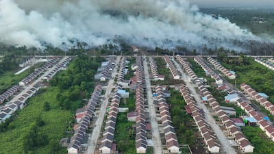Smoke rises from a wildfire next to a housing complex in Indonesia. AFP