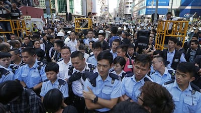 Police officers stand guard at an occupied area in Mong Kok district. Hong Kong authorities on Tuesday began clearing away some barricades from part of the pro-democracy protest site, scene of previous violent confrontations with police and angry mobs. Kin Cheung / AP