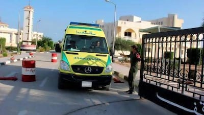 An ambulance carrying the bodies of Egyptian police officers leaves a hospital to head to the airport in Arish.