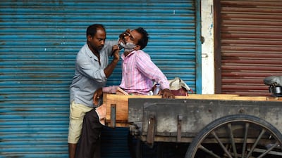 A man gets a shave outside closed shops during a government-imposed nationwide lockdown as a preventative measure against the COVID-19 novel coronavirus in the old quarters of New Delhi. AFP