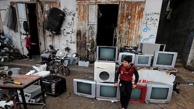 A Palestinian boy sits on TV sets for sale at a shop for used appliances in Gaza City. AFP