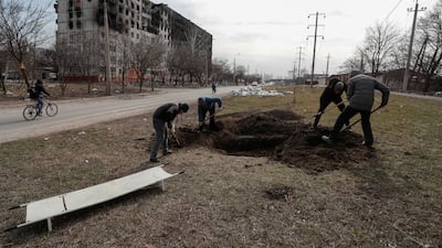 Graves are dug in a street in the besieged southern port city of Mariupol. Reuters