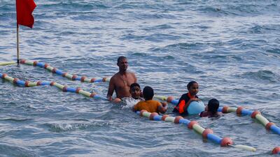 A lifeguard helps visually impaired children swim at Al Mandara beach. Reuters