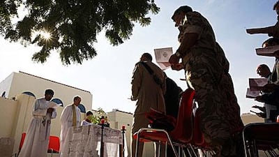 Father John Weir, second from left, leads the service of remembrance at the restored military cemetery at St Martin's church in Sharjah on Wednesday.