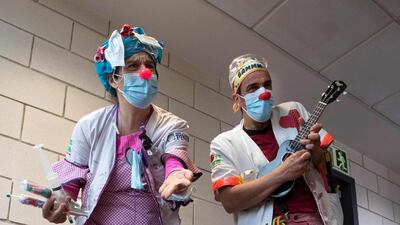 Two clowns of the Sunrise Media NGO (Medical Smile) perform at the Son Llatzer Hospital in Palma de Mallorca, Spain. AFP