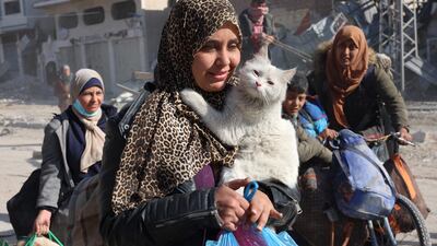 A Palestinian woman carries her cat as displaced people from Beit Lahia arrive in Jabalia in northern Gaza. AFP