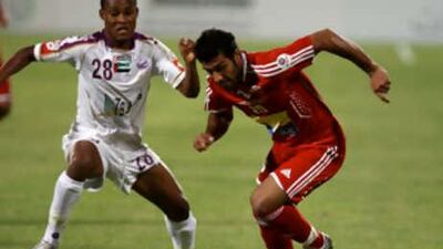 Melad Medwady from Al Ahli, right, and Al Prensno from Al Ain, left, during the football match at Al Ahli football ground in Dubai.