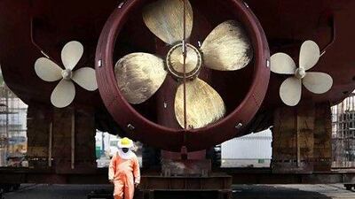 A worker walks while moving a ship at Drydocks World facilities. ( Jaime Puebla / The National )
